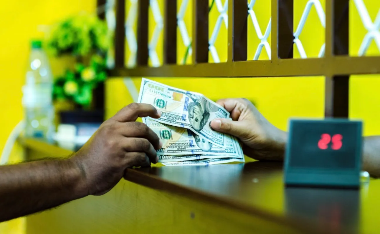 މީހަކު ޑޮލަރު ގަންނަނީ- ފޮޓޯ/ އަވަސް