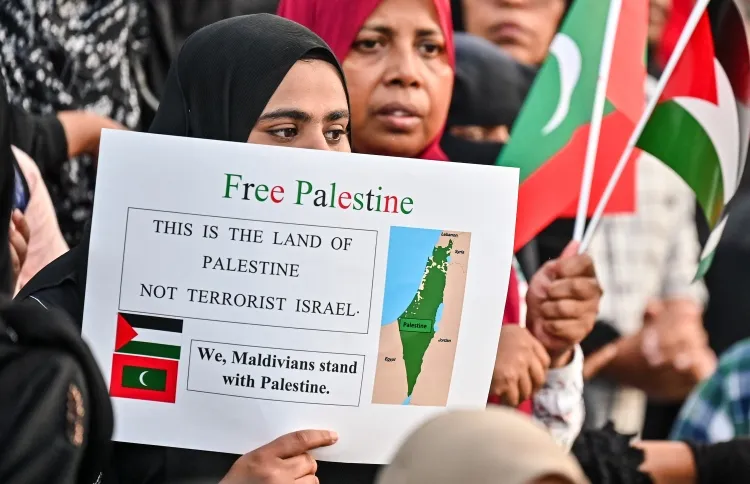 A woman holding a Free Palestine poster on a walk for Palestine on October (Photo/Mihaaru)
