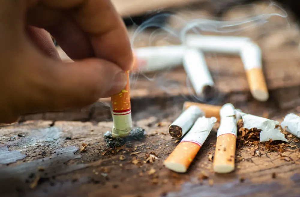 Person puts out a lit cigarette (Photo/Getty Images)