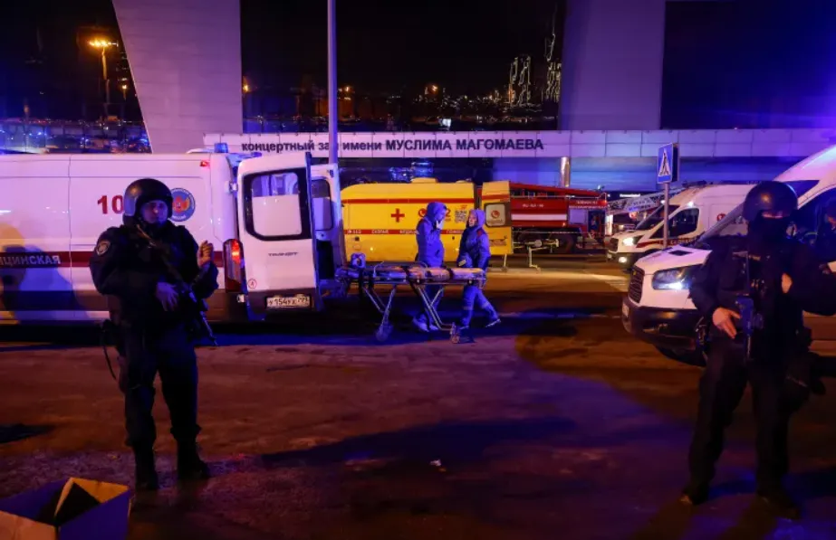 Russian law enforcement officers stand guard near the burning Crocus City Hall concert venue following a shooting incident outside Moscow (Photo/Al Jazeera)