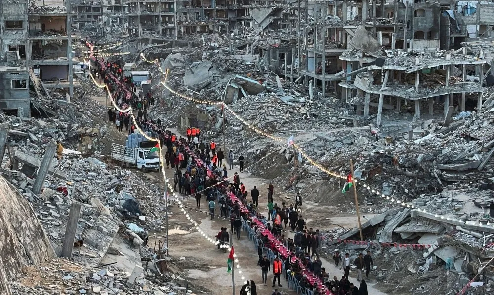 A red-covered table stretching several hundred metres carved a path through mounds of rubble in southern Gaza on Saturday, as families gathered to break their fast during the first day of the Muslim holy month of Ramadan (Photo/AFP)
