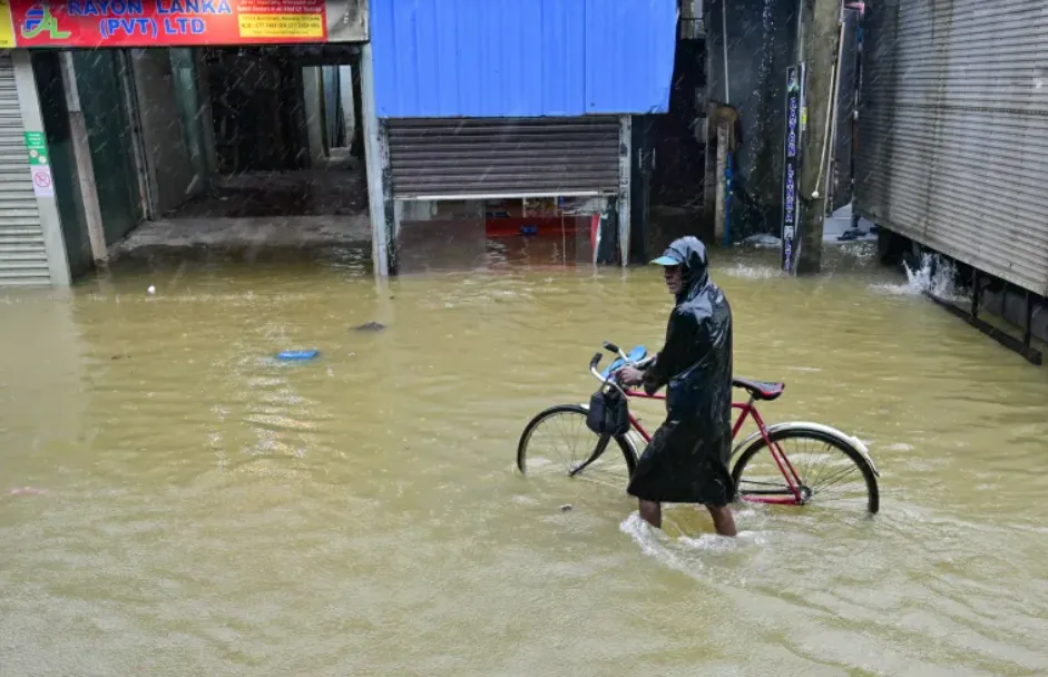 A resident wades through a flooded street after heavy rains in Malwana on the outskirts of Colombo (Photo/Ishara S Kodikara/AFP)