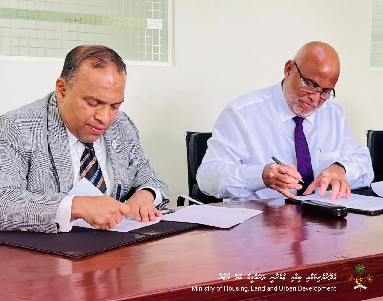 ހައުސިން މިނިސްޓްރީއިން މޯލްޑިވިސް އިސްލާމިކް ބޭންކާއެކު ފަހުމުނާމާއެއްގައި ސޮއިކުރުން --- ފޮޓޯ: ގެދޮރުވެރިކަމާއި ބިމާއި ޢުމްރާނީ ތަރައްޤީއާބެހޭ ވުޒާރާ