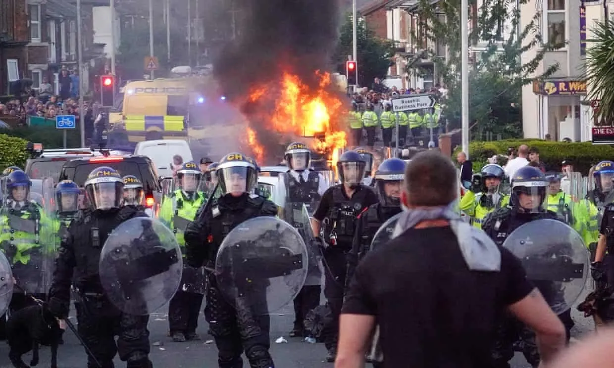Burning police vehicle amid the southport protests (photo/the gaurdian)
