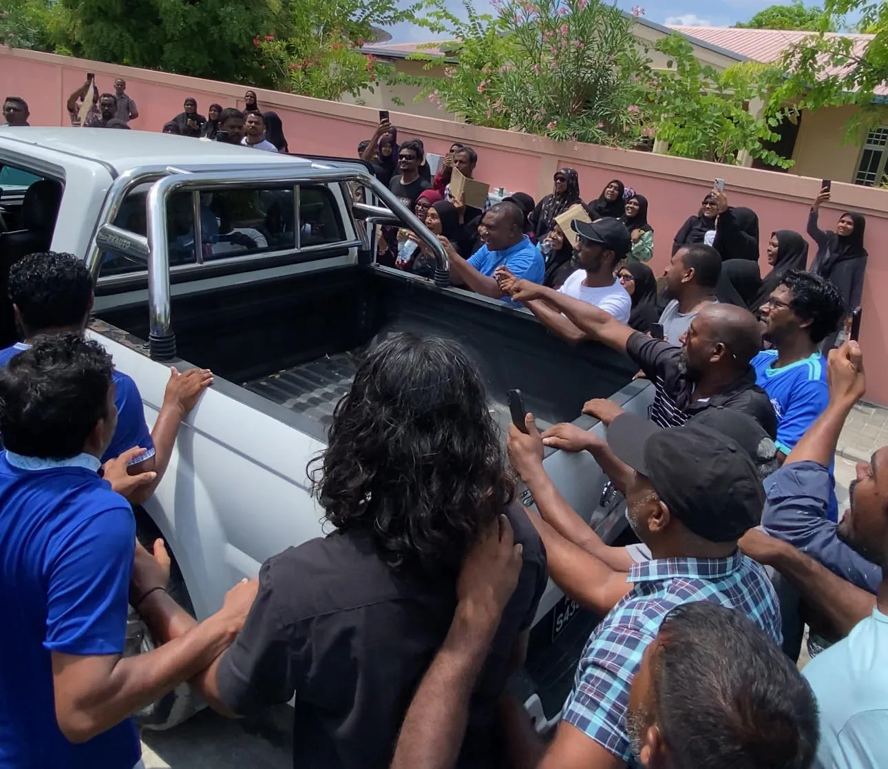 ޕޮލިސް ސްޓޭޝަނުން ތުހުމަތު ކުރެވޭ މީހާ ނެރެގެން މެޖިސްޓްރޭޓު ކޯޓަށް ގެންދިޔަ ގަޑީގައި އާންމުން ފުލުހުންގެ ވެހިކަލް ވަށާލަނީ- ފޮޓޯ/ ވަގުތު