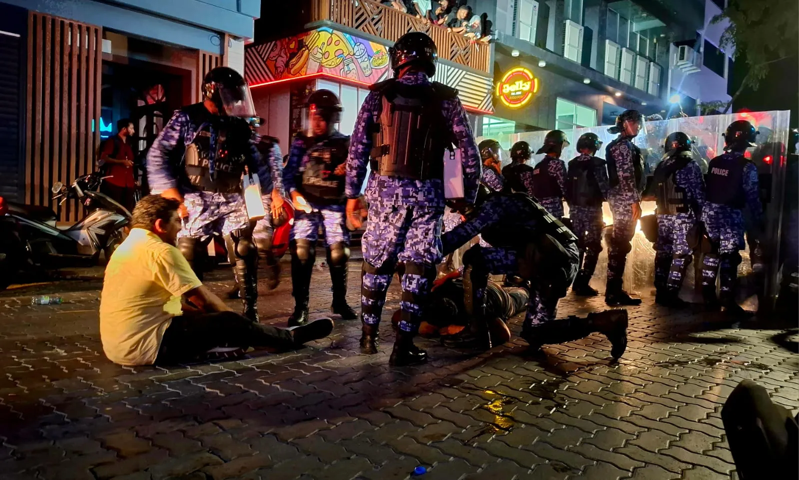 މުޒާހަރާގެ ބައިވެރިއަކު ފުލުހުންގެ ބެލުމުގެ ދަށަށް ގެނައުމުގެ ތެރެއިން... ފޮޓޯ: ވޮއިސް
